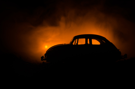 Silhouette of police car chasing a car at night with fog background. 911 Emergency response police car speeding to scene of crime. Selective focusの写真素材