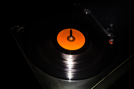 Turntable playing vinyl with glowing abstract lines concept on dark background