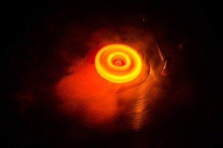 Turntable playing vinyl with glowing abstract lines concept on dark backgroundの写真素材