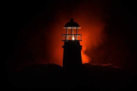 Scary dark ominous lighthouse behind a red fire background. Lighthouse at dusk/ Sunset Light House/ Light house at sunsetの写真素材