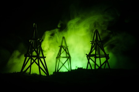 Oil pump oil rig energy industrial machine for petroleum, Group oil rigs and brightly lit industrial site at night. Toned.Background for design. Selective focusの写真素材