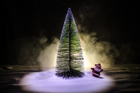 Happy Santa Claus Doll on Christmas time with tree and snow.の写真素材