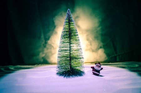 Happy Santa Claus Doll on Christmas time with tree and snow. Colorful bokeh background. Santa Clause...
