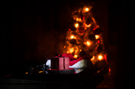 Dj mixer with headphones on dark nightclub background with Christmas tree New Year Eve. Close up view of New Year elements or symbols (Santa Clause, Snowman, Dog 2018, gift box) on a Dj table.の写真素材