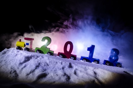2018 happy new year,wooden toy train carrying numbers of 2018 year on snow. Toy train with 2018. Copy space.の写真素材