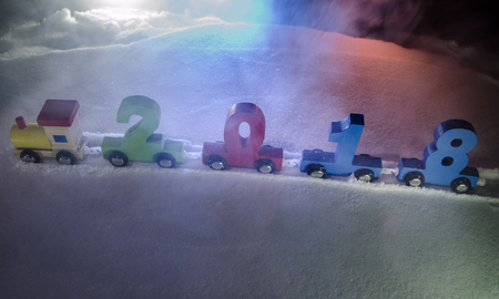 2018 happy new year,wooden toy train carrying numbers of 2018 year on snow. Toy train with 2018....