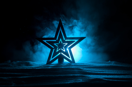 Christmas background with festive decoration, star on dark blue background with copyspace. Selective focus. Snowflakes on snowの写真素材