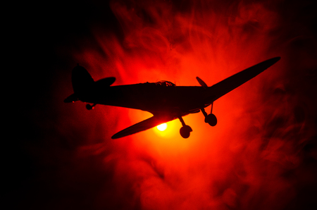 World war ii fighter plane at sunset or dark orange fire explosion sky. War scene. German figher at sky. Selective focusの写真素材