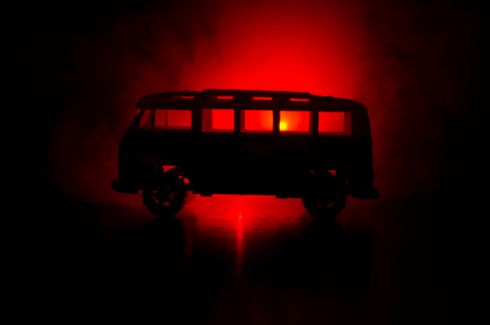 The car in the shadows with glowing lights in low light, or silhouette of sport car dark background. Selective focusの写真素材
