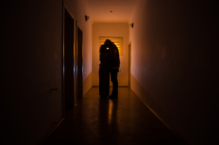 Dark corridor with cabinet doors and lights with silhouette of spooky horror man standing with different poses. Halloween conceptの写真素材
