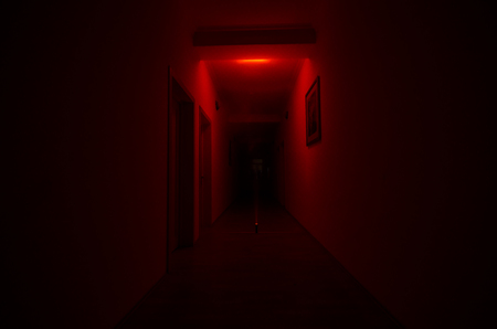 Dark corridor with cabinet doors and lights with silhouette of spooky horror man standing with different poses. Halloween conceptの写真素材