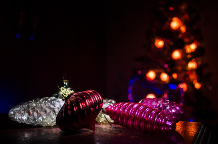 Christmas toys on table at decorative fir-tree blurred with lights. Making a Christmas tree on table. Empty space. Useful as greeting card. Selective focusの写真素材