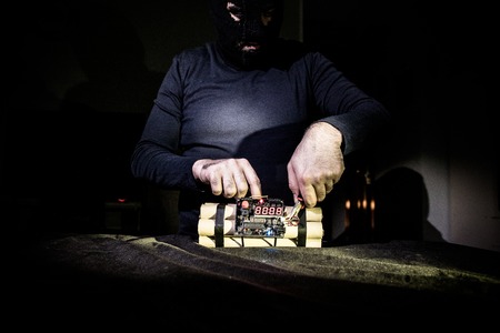 Terrorist making timebomb. terrorism and dangerous concept. Dark background