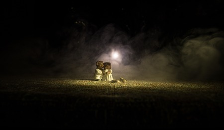 Stuffed bride and groom bears standing together with LED heart on dark foggy background. Selective focusの写真素材