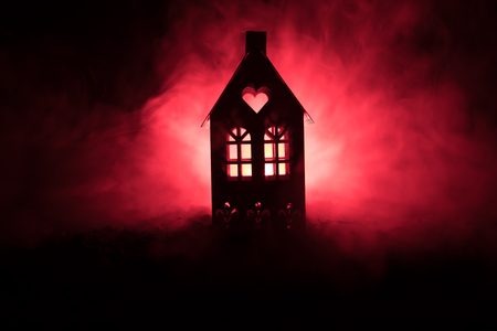 Black house with a heart and toned foggy sky in the background. Suitable for concepts such as Love house for Valentine`s Day. Selective focusの写真素材