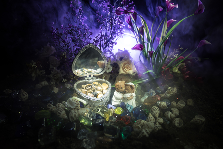 Love concepts of wedding teddy bear in silver heart gift box on table for valentines day and wedding. Dark smoky toned background. Selective focusの写真素材