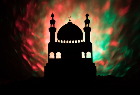 Silhouette of mosque building on toned foggy background. Ramadan Kareem background. Mosque at sunset. Praying peopleの写真素材