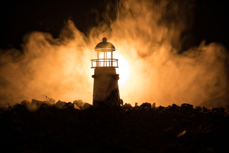 Lighthouse with light beam at night with fog. Selective focusの写真素材