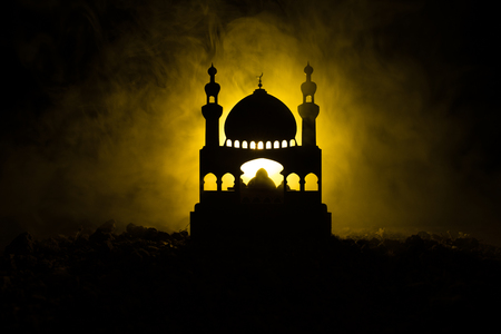 Silhouette of mosque building on toned foggy background. Ramadan Kareem background. Mosque at sunset. Praying peopleの写真素材
