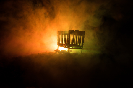 Old creepy eerie wooden baby crib in dark toned foggy background. Horror concept. Scary baby and bed silhouette in dark. Halloween decoration shot. Selective focusの写真素材