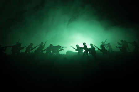 War Concept. Military silhouettes fighting scene on war fog sky background, World War Soldiers Silhouettes Below Cloudy Skyline At night. Attack scene. Armored vehicles. Tanks battle. Decorationの写真素材