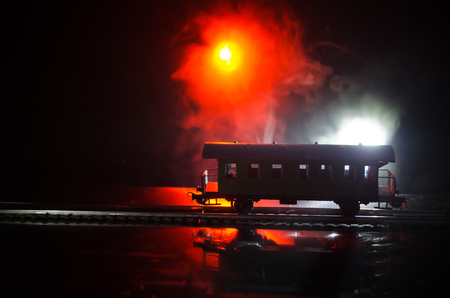 Train moving in fog. Ancient steam locomotive in night. Night train moving on railroad. orange fire background. Horror mystical sceneの写真素材