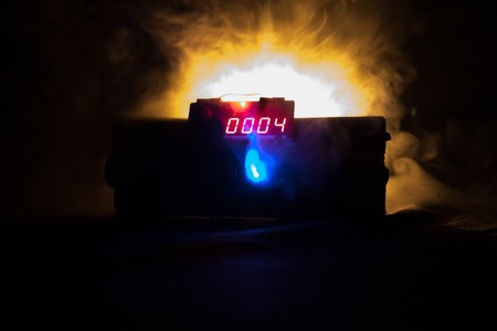 Image of a time bomb against dark background. Timer counting down to detonation illuminated in a shaft light shining through the darkness, conceptual imageの写真素材