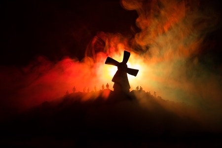 Silhouettes crowd of hungry zombies and old windmill on hill against dark foggy toned sky. Silhouettes of scary zombies walking at night. Horror Conceptの写真素材