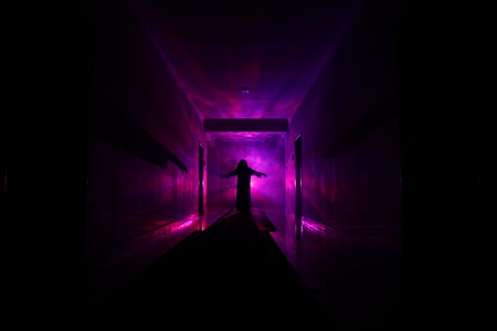 Creepy silhouette in the dark abandoned building. Horror about maniac concept or Dark corridor with cabinet doors and lights with silhouette of spooky horror person standing with different poses.の写真素材