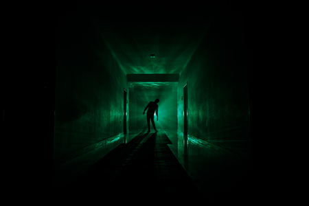 Creepy silhouette in the dark abandoned building. Horror about maniac concept or Dark corridor with cabinet doors and lights with silhouette of spooky horror person standing with different poses.の写真素材