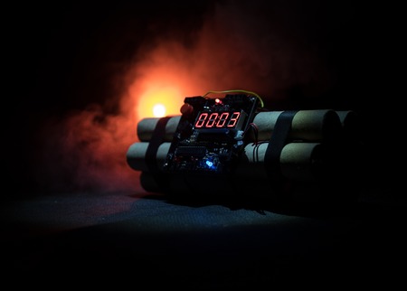 Image of a time bomb against dark background. Timer counting down to detonation illuminated in a shaft light shining through the darkness, conceptual imageの写真素材