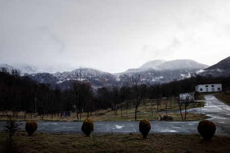 Beautiful landscape of mountains and forest with village building or old abandoned ruined brick house. Foggy forest and old building or old wooden hut cabin in mountain alps at rural fall landscapeの写真素材