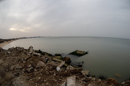 Beautiful landscape of abandoned house on rocky seashore at sunset time. Cloudy weather. Caspian Sea, Azerbaijan, Novkhaniの写真素材
