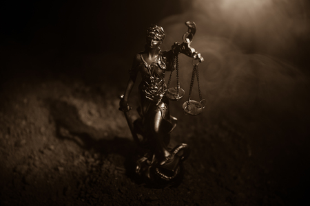 The Statue of Justice - lady justice or Iustitia / Justitia the Roman goddess of Justice on a dark fire background. Selective focusの写真素材