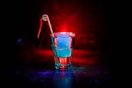 Alcohol cocktail in glass with ice in smoke on dark toned background. Club drinks concept. One glass of cocktailの写真素材