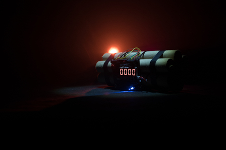 Image of a time bomb against dark background. Timer counting down to detonation illuminated in a shaft light shining through the darkness, conceptual imageの写真素材