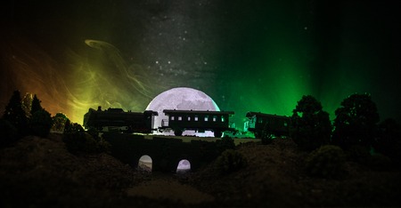 Train moving in fog. Ancient steam locomotive in night. Night train moving on railroad. toned foggy fire background. Horror mystical scene. Selective focusの写真素材