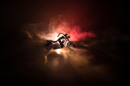 High power motorcycle chopper. Fog with backlights on background with man rider at night. Empty space. Selective focusの写真素材