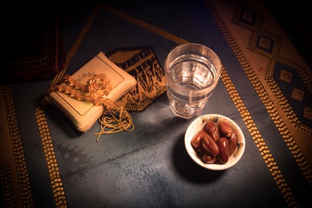 Water and dates. Iftar is the evening meal. View of decoration Ramadan Kareem holiday on carpet....