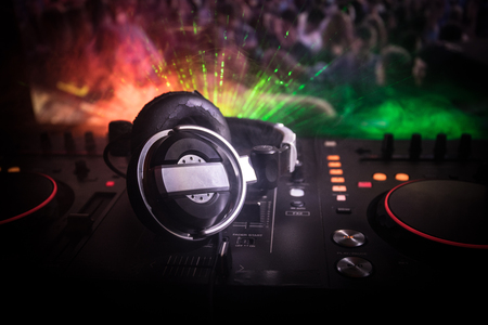 In selective focus of Pro dj controller.The DJ console deejay mixing desk at music party in nightclub with colored disco lights. Close up viewの写真素材