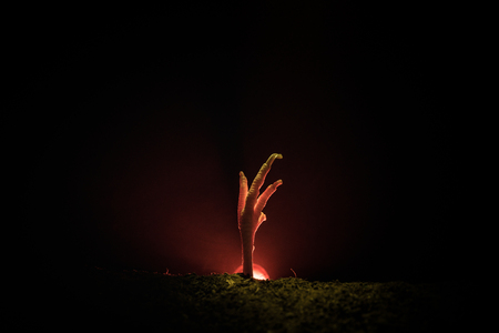 Halloween concept, zombie hand rising out from the ground or zombie hand coming out of his grave
