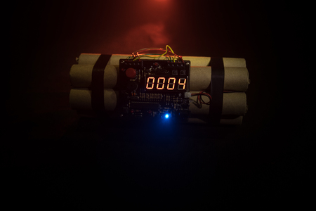 Image of a time bomb against dark background. Timer counting down to detonation illuminated in a shaft light shining through the darkness, conceptual imageの写真素材