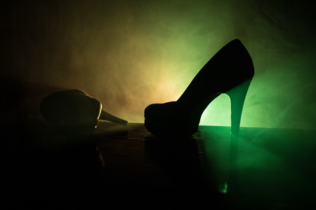 Black suede high heel women shoes on dark toned foggy background. Close up. Women power or women domination concept. Selective focusの写真素材