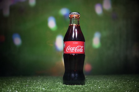 BAKU,AZERBAIJAN - JULY 01, 2018 : Creative concept. Coca-Cola Classic in a glass bottle on grass. Support your country in World cup 2018. Selective focusのeditorial素材