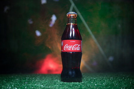 BAKU,AZERBAIJAN - JULY 01, 2018 : Creative concept. Coca-Cola Classic in a glass bottle on grass. Support your country in World cup 2018. Selective focusのeditorial素材