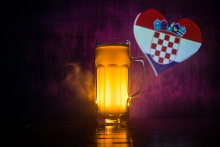 Soccer 2018. Single beer glass on table at dark toned foggy background. Support Croatia with beer concept. Selective focusの写真素材