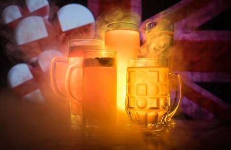 Soccer 2018. Beer glasses on table at dark toned foggy background. Support England with beer concept. Selective focusの写真素材