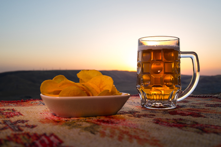 Close Up of A Glass of Beer with the snacks on Sunlight Background. Selective focusの写真素材