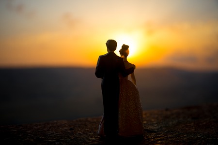 silhouette of wedding Couple statue holding hand together during sunset with evening sky background. Wedding concept. Selective focusの写真素材