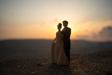 silhouette of wedding Couple statue holding hand together during sunset with evening sky background. Wedding concept. Selective focusの写真素材